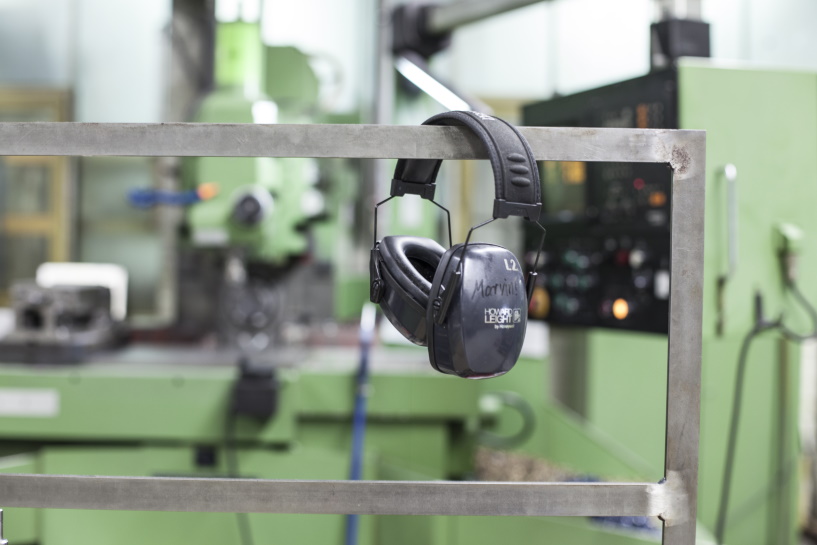 Gehörschutz hängt über einem Metallgeländer